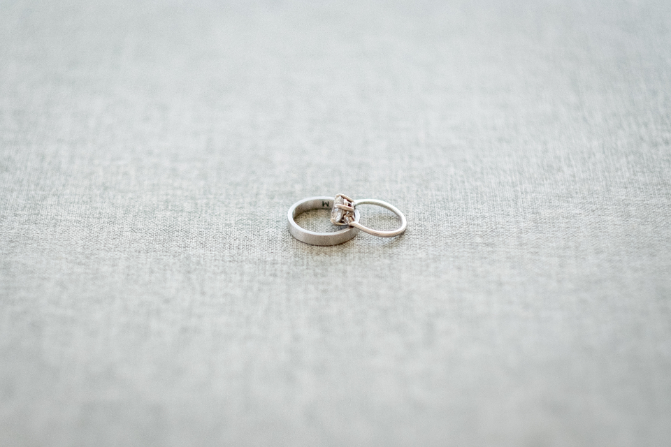 Duas alianças de casamento entrelaçadas sobre um tecido claro